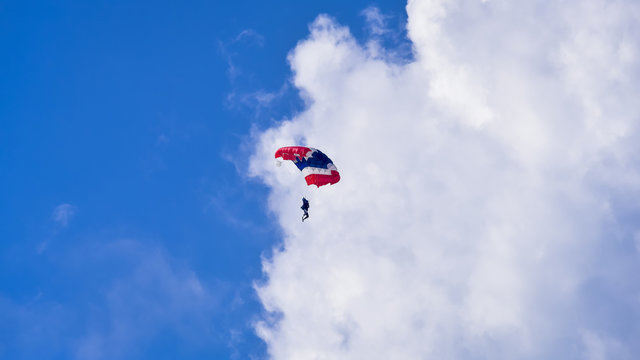Skydriver jumping with parachut with blue cloud sky background