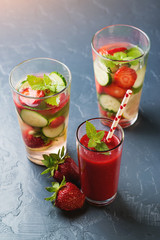 Strawberry smoothie and healthy detox drinks on black background.