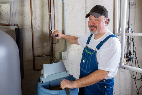 Friendly Workman Working On A Water Softener