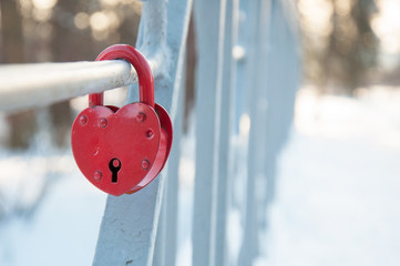 Metal lock in the form of a red heart on the bridge, background love forever, Valentine's Day