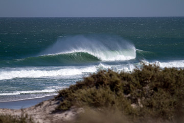 perfect wave crashing in a stormy sea, windy, weather, beach