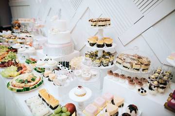 Delicious white wedding Candy bar. Table with sweets, candies, dessert