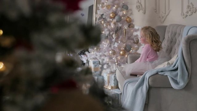 the girl lies on the couch in the Studio. Christmas interior