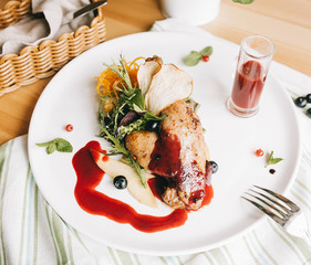 duck leg confit on polenta with cranberry-honey sauce on a wooden table