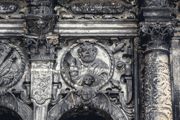 Black medieval religious bas-reliefs on the walls of an ancient church