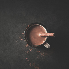 Vintage mug of hot cocoa with cinnamon sticks