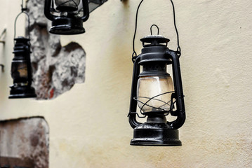 Old kerosene lamps hang on the wall in the city