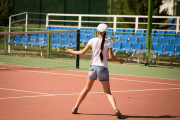 Girl playing with a racket in tennis on the court
