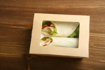 Delivery of food at home. Shaurma without sauces with chicken, pepper, salad in a cardboard container. Low-calorie lavash roll. Without frying, uncooked.