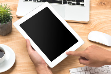 Hand using digital tablet with blank screen on desk work table