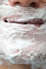 A man is applying face shaving foam