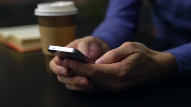 Man drinking coffee while using a phone