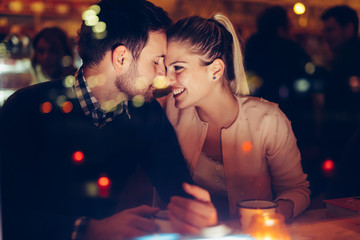 Obraz na płótnie Canvas Romantic couple dating in pub at night