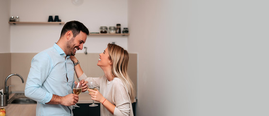 Attractive couple in kitchen talking and smiling.