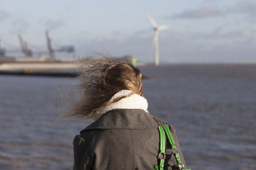 young woman enjoys windy seaside view