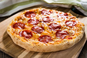 Pepperoni pizza on rustic background