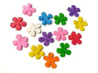 Colorful flowers made from plasticine, multicolored clay dough arrange heart shaped on white background