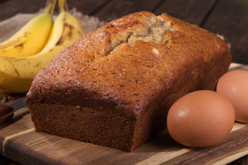 Loaf of banana nut bread with brown eggs and bananas