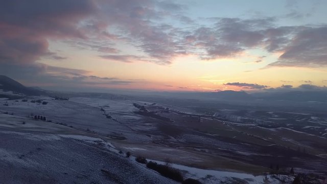 Aerial view of evening sunset color over snowy fields