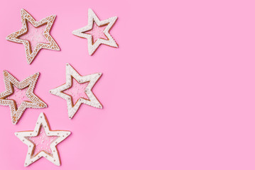Fototapeta na wymiar Christmas gingerbreads stars on sweet pink background.Top view image. Copyspace for your text.