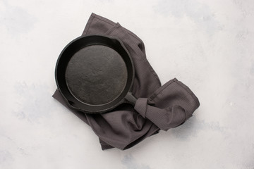 empty black cast iron drip pan on light concrete background. idea for menu or recipe or for culinary background