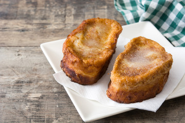 Traditional homemade Spanish torrijas on wooden background. Easter dessert.