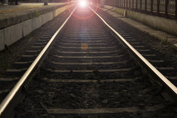 Fototapeta na wymiar railroad in motion at sunset railway station