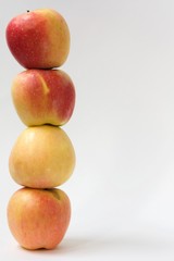 pyramid of the four red and yellow apples on wite background