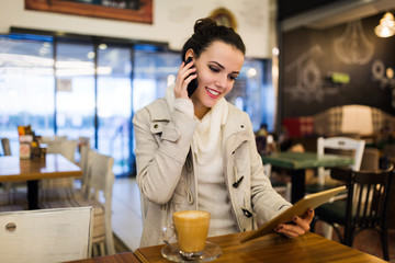 Attractive young woman using tablet in cafe