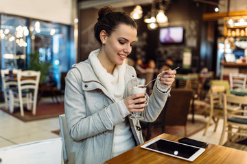 Attractive young woman using tablet in cafe