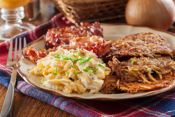 Hash browns. Potato pancakes with crispy fried bacon and scrambled eggs