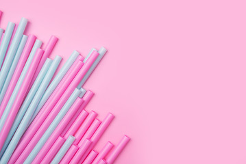 colorful cocktail tubes lie on a bright pink background. Top view image. Copyspace for your text.