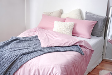 Comfortable bed with soft pillows indoors