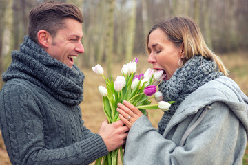 couple outdoors with flowers being silly and happy