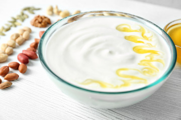 Tasty yogurt with honey in bowl, closeup