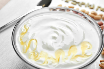 Tasty yogurt with honey in bowl, closeup