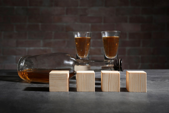 Alcohol and wooden cubes on table