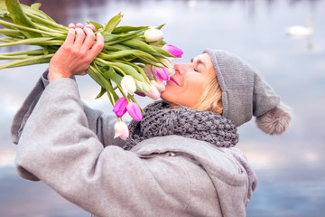 blond woman in front of lake with tulips