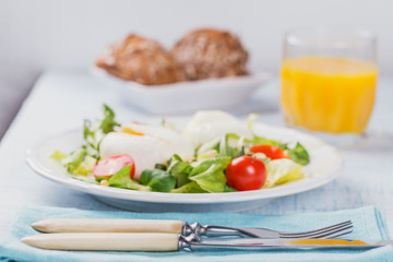 Poached egg with green salad, tomatoes, wholemeal bread and orange juice