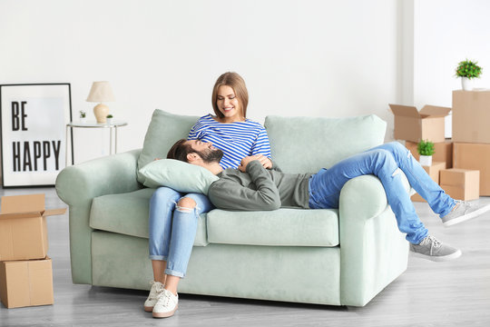 Young couple resting on sofa after moving to new home