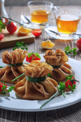 Pancakes with meat, tied with green onions