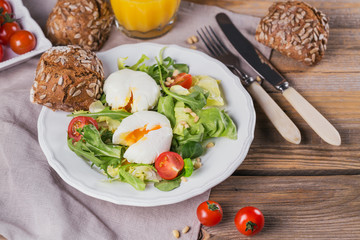 Poached egg with green salad, tomatoes, wholemeal bread and orange juice