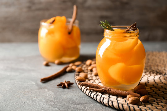 Jar with pickled apricots on table