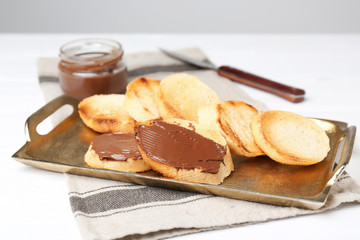 Metal tray with toasted bread on table