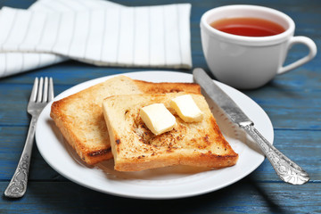 Plate with toasted bread on table