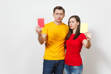 European serious severe young woman and man, football referee hold choose yellow and red soccer cards, propose player retire from field isolated on white background. Sport, play, lifestyle concept.