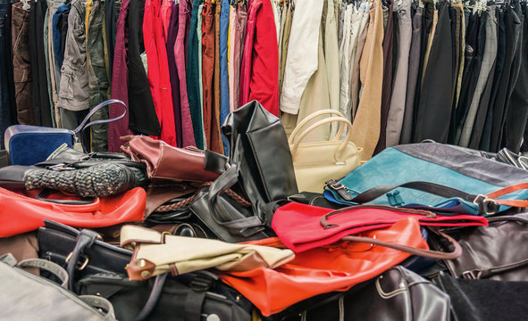 Verkauf secondhand Handtaschen auf dem W&uuml;hltisch und gebrauchte Kleider im Kleiderst&auml;nder - Sale secondhand handbags on the bargain counter and second-hand clothes in the clothes rack
