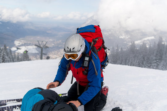 Kameraden der Bergwacht versorgen eine gestürzte und verletzte Skifahrerin
