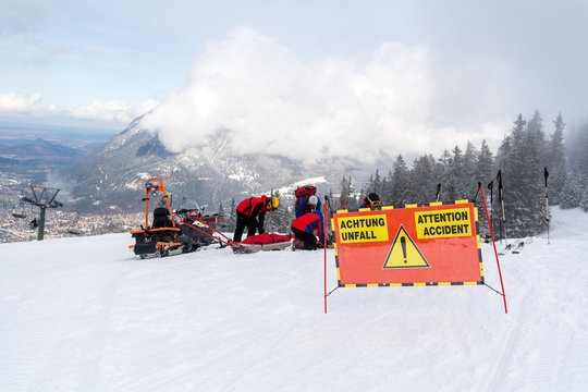 Kameraden der Bergwacht versorgen eine gest&uuml;rzte und verletzte Skifahrerin