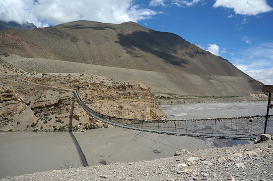 Pedestrian suspension bridge over the Kali Gandaki River. Trekking to the closed zone of Upper Mustang. Nepal.